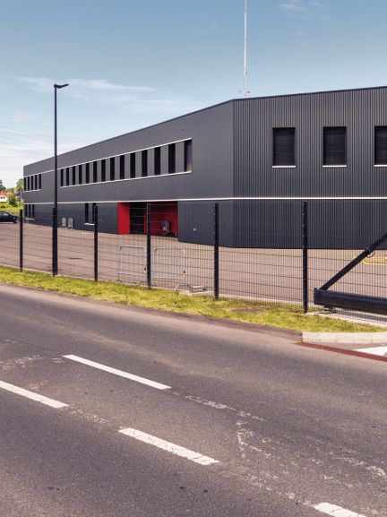 Vista esterna dell'edificio con strada e recinzione Centre de renfort de la Veveyse