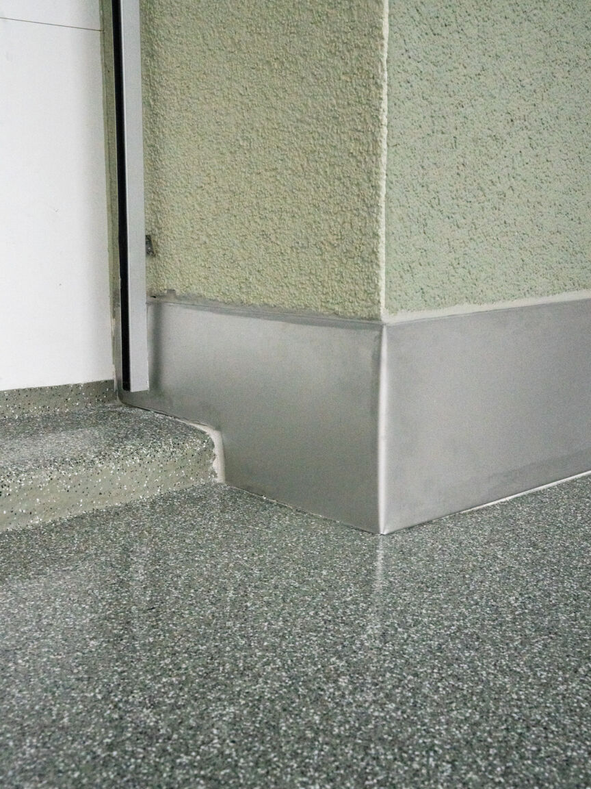 Grauer Flüssigkunststoff Balkonboden mit Metall Fussleiste und grüner Wand Objektreportage Flüssigkunststoff Widen